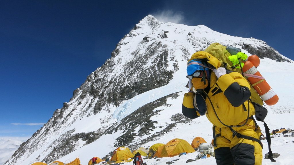 一名雪巴人在珠穆朗瑪峰揹運帳棚與物資上山。 圖／法新社