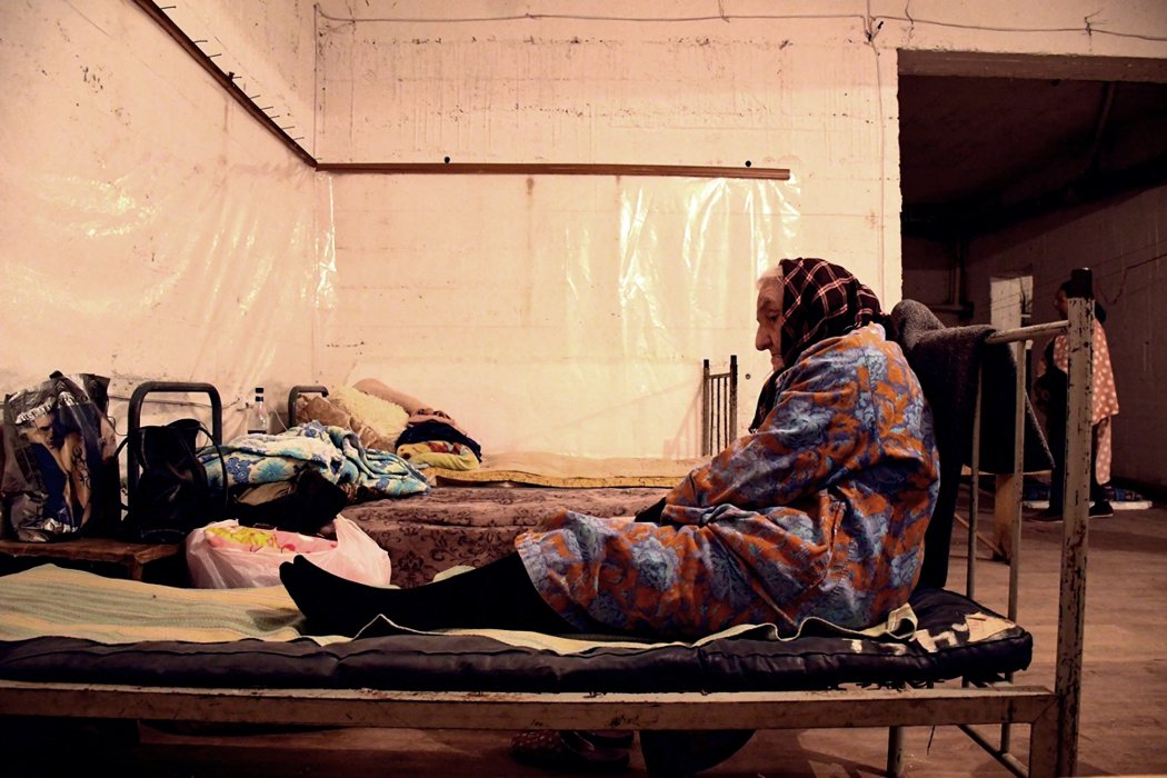 納卡地區一名老婦人，暫時躲在民宅地下室作為防空洞，躲避砲擊。 圖／法新社