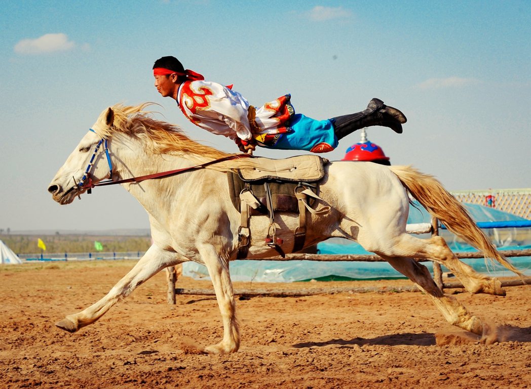 內蒙古鄂爾多斯成吉思汗陵附近的那達慕會場，蒙古族傳統馬術表演。 圖／新華社