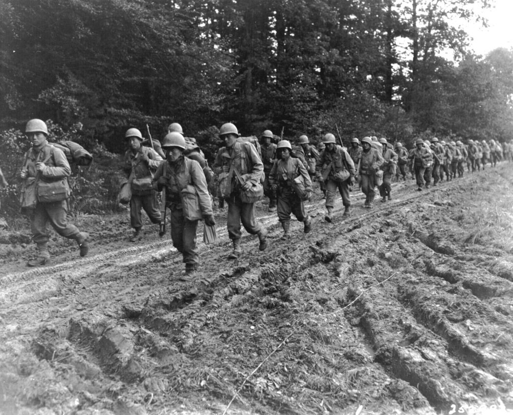 第442步兵戰鬥團的日裔步兵在法國尚布瓦區的一條路上行走，攝於1944年。 圖／維基共享