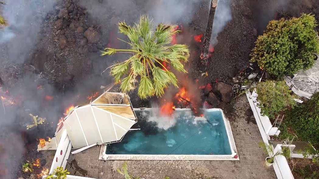 圖為火山熔岩流經游泳池的剎那，水面開始沸騰。 圖／美聯社