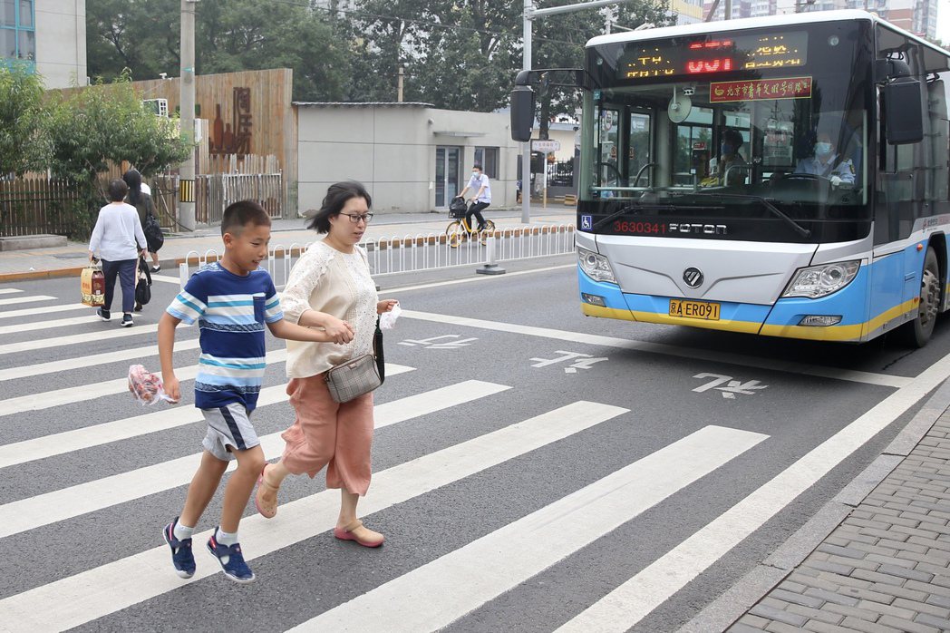 圖為中國北京行人通過馬路示意圖。 圖／中新社