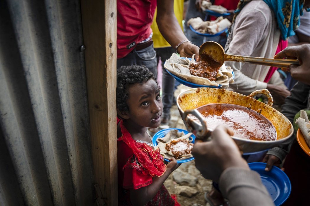 一名兒童在默克萊一處接收難民的中心領取居民捐贈的食物。 圖／美聯社