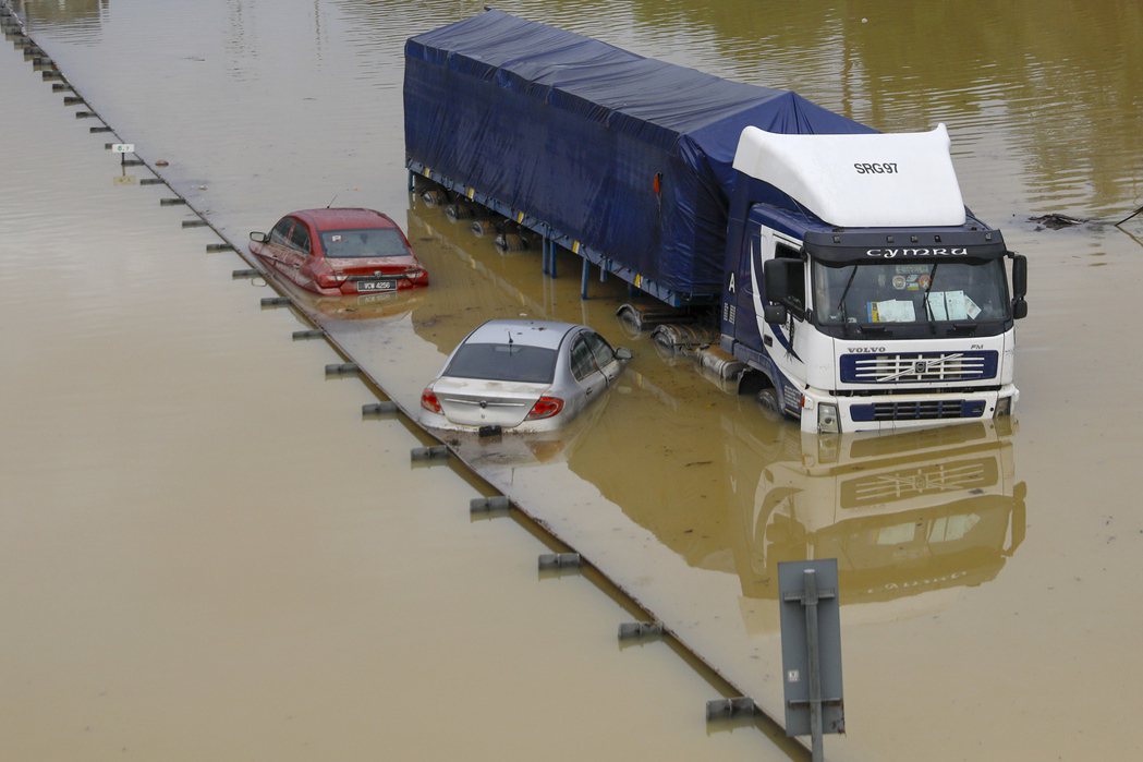 洪水來襲，有些民眾在路上被突然高漲的洪水逼得棄車而逃。 圖／歐新社