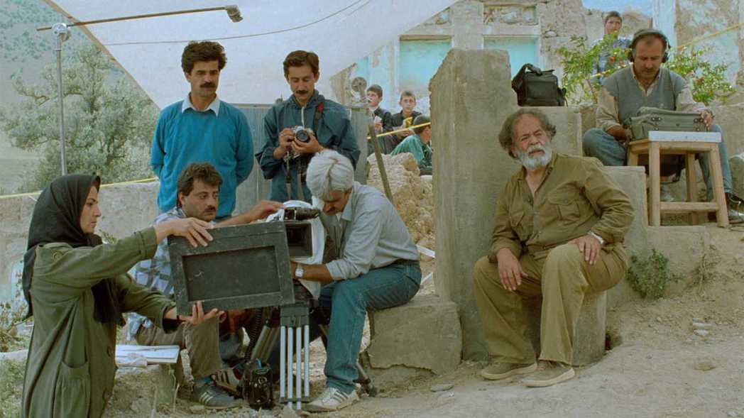 穿藍衣者是以《計程人生》獲柏林影展金熊獎的賈法潘納希（Jafar Panahi），他在《橄欖樹下的情人》中擔任助理導演，也同時出現在電影當中。 圖／取自IMDb