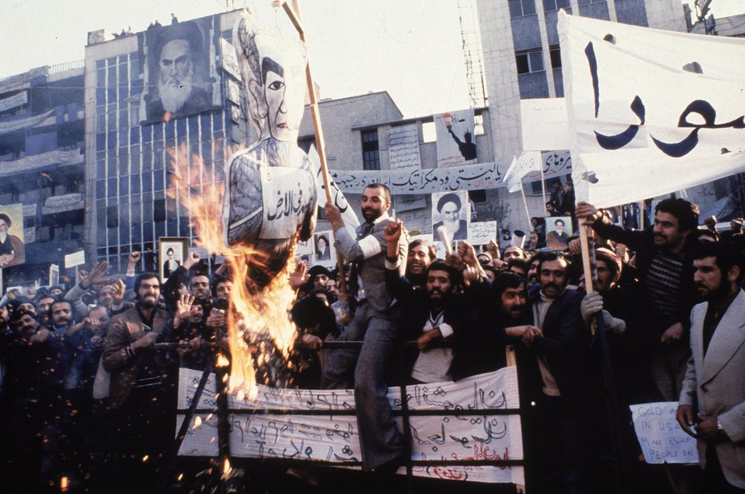 1979年，德黑蘭民眾聚集美國駐伊朗大使館抗議，高呼支持何梅尼，並燒毀巴勒維國王...