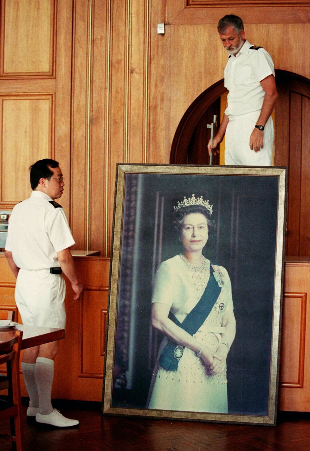  1997年6月16日——香港主權移交兩星期前——香港官員移除英女皇的肖像。 圖...