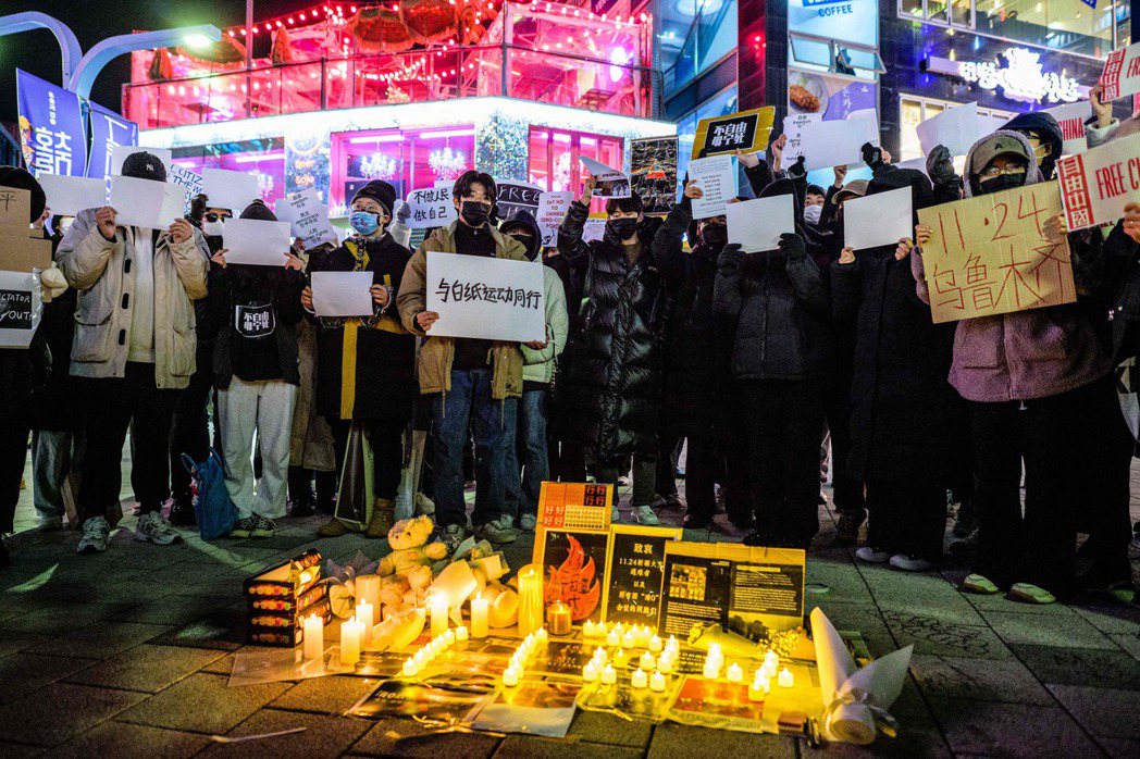 中國留學生以燭火排出「11‧24」的字樣，悼念新疆火災及各種因「清零」政策而去世...