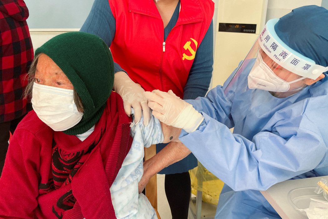 上海郊區一名老婦人正在接受疫苗接種。 圖／路透社
