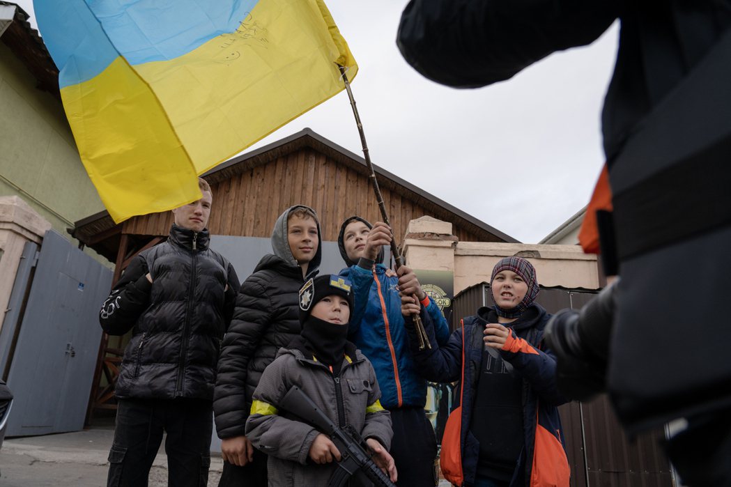 赫爾松的孩子因應烏軍收復當地而揮動國旗拍照。 圖／陳彥婷攝