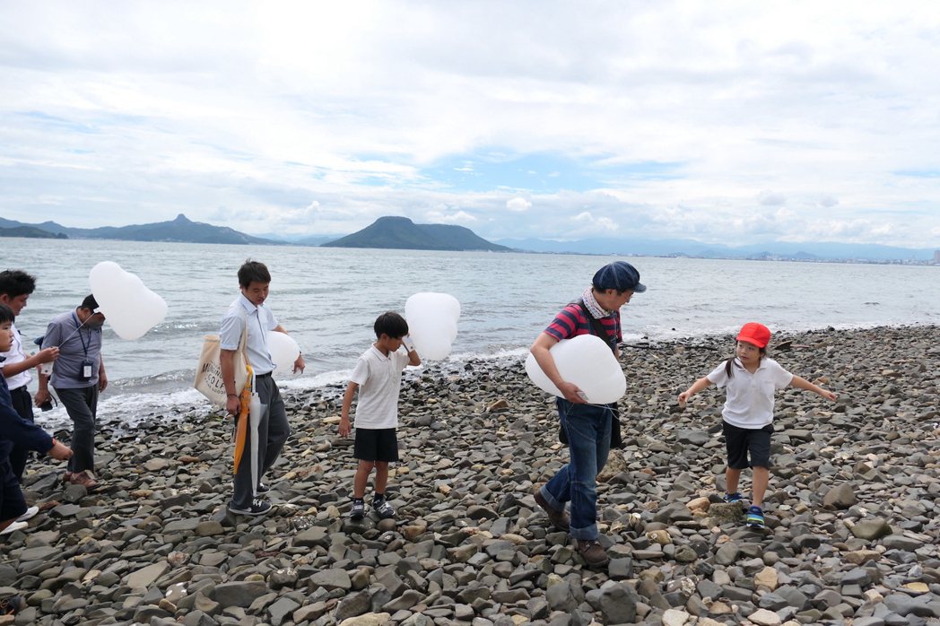 藝術家高橋匡太帶領學生們在海邊撿拾男木島的石頭，此後他將把這些石頭帶到馬祖，讓男...