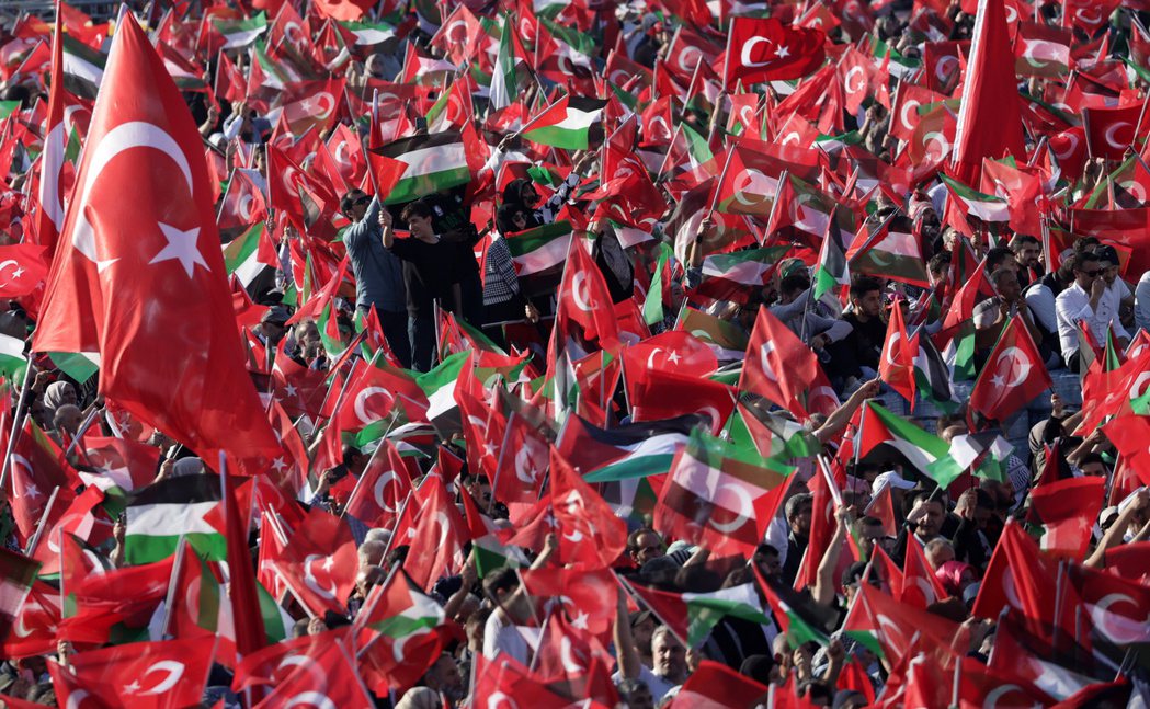  厄多安的支持者集會中，參與民眾高舉自家國旗與巴勒斯坦旗。 圖／歐新社 