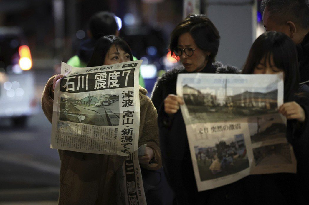 圖為閱讀地震號外新聞的日本民眾。 圖／美聯社