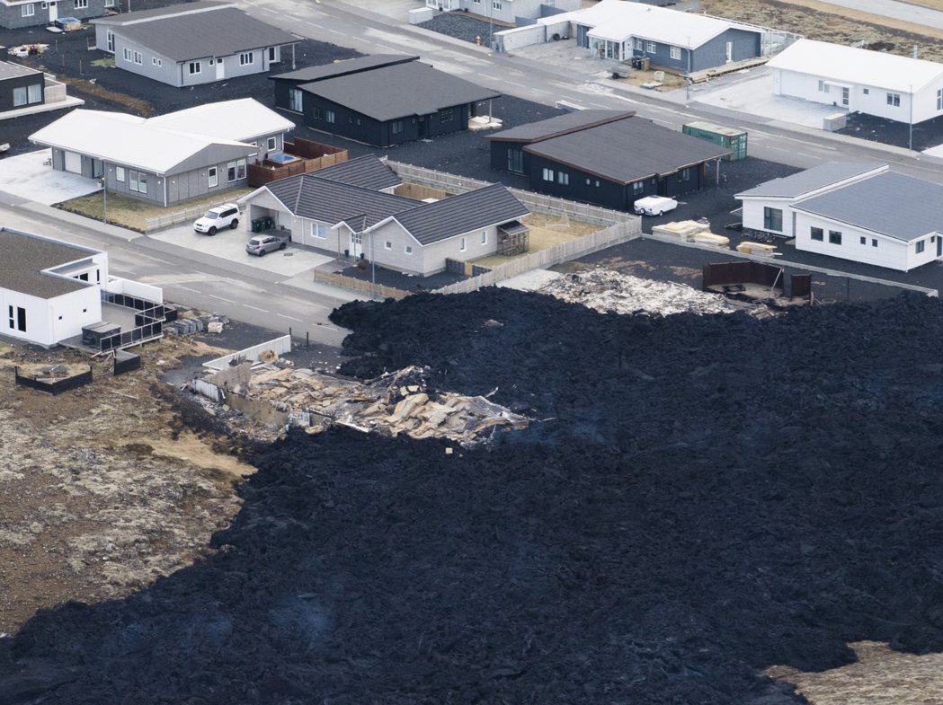 冰島法拉格達爾火山14日噴發，大量熔岩湧向格林達維爾鎮上。圖中黑色部分即為冷卻後...