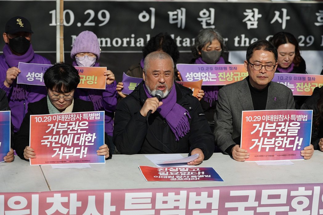 罹難者家屬協議會代表李正民（圖中央持麥克風者），在許多犧牲者父母陪同下，於首爾市...