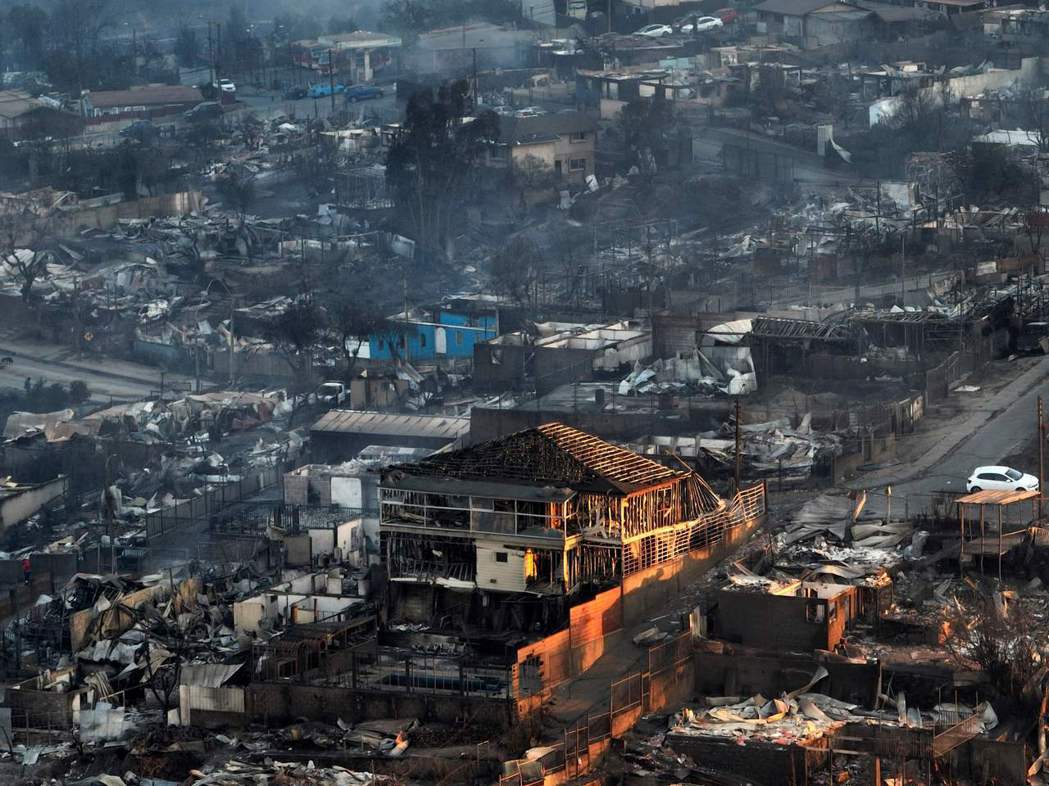 智利沿海城市維涅馬爾被森林大火燒到焦黑的街道和建築，許多居民只來得及帶上自己或親...