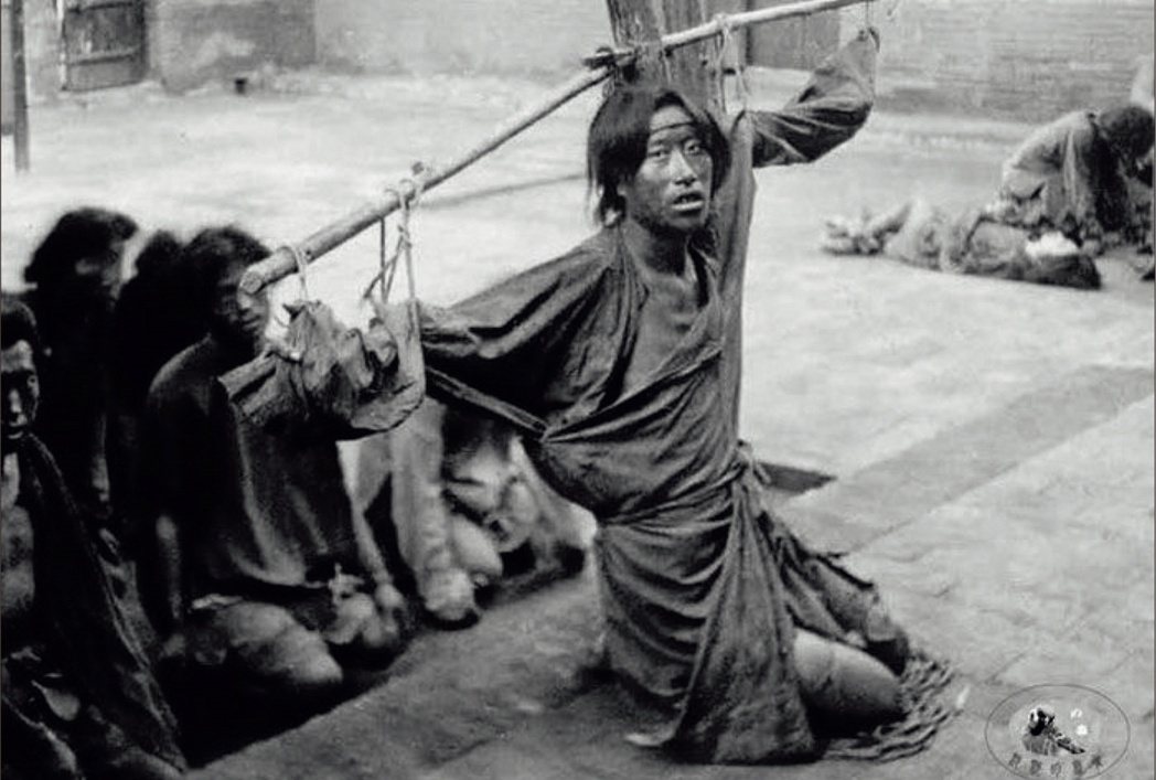 一名年輕人在衙門院子裡遭到刑求的照片，可能是在中國北方，時間在1900年之後不久...