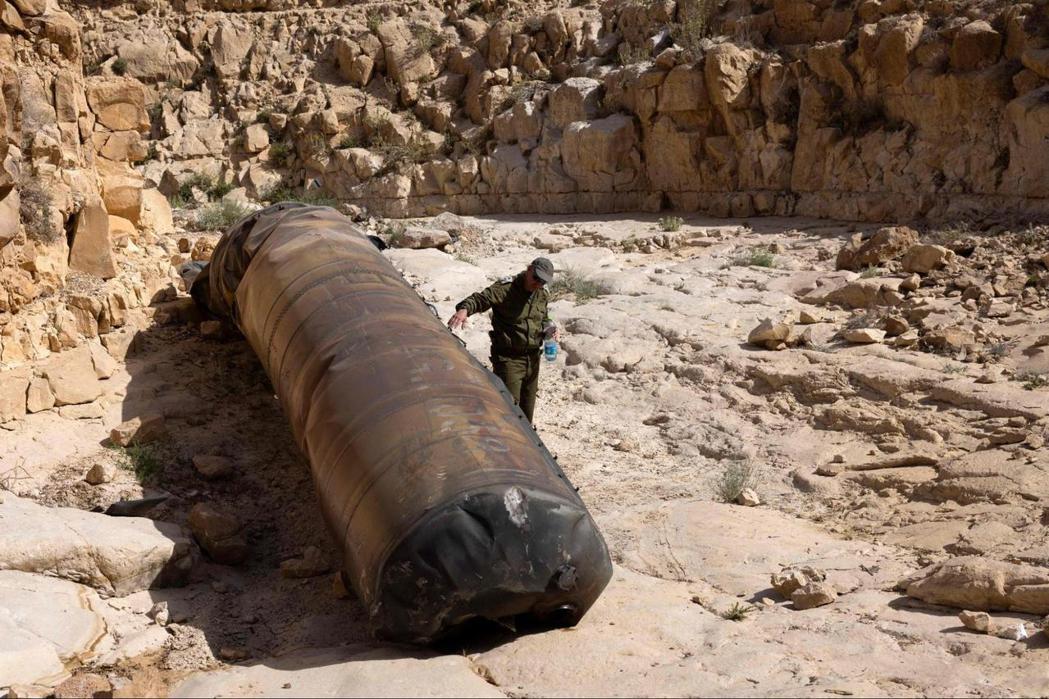 2024年4月24日，一名以色列軍事人員檢查落在南部城市阿拉德附近空地上的伊朗彈...