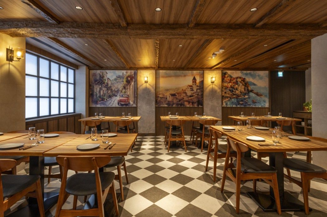 餐廳整體空間以木質系營造出義大利餐館溫暖氛圍，室內黑白菱格復古地磚、暖黃壁燈、木...