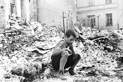 德國在1939年9月入侵波蘭，此檔案照片為當時一名波蘭小男孩回家，蹲在廢墟之中。...