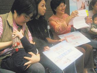 一群哺乳媽媽帶著寶寶在衛生署慶祝法定保障公開哺育母乳。 圖／中央社