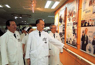 慈濟醫療志業執行長林俊龍（右二）、慈濟院長高瑞和（右一）等人觀賞慈院榮獲「台灣百大品牌」兩人受獎的海報。 記者范振和／攝影