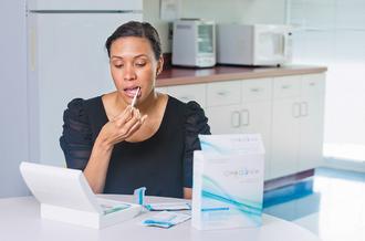 美國食品暨藥物管理局3日批准HIV病毒檢驗器OraQuick上市。圖為OraSure公司的廣告顯示使用者拿OraQuick檢驗器從口腔採得唾液樣本。 美聯社