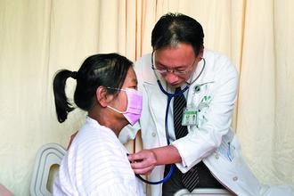 游女士（左）急性肺栓塞發作，術後恢復狀況良好，醫生正替她做檢查。
圖／台中市慈濟醫院提供