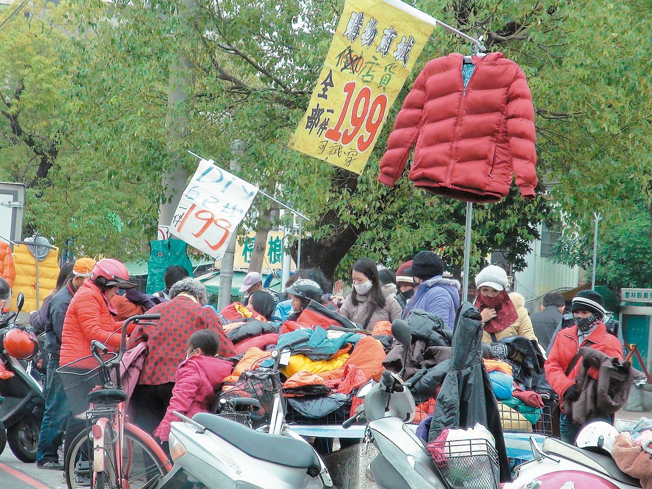 天氣冷颼颼，雲林縣斗六市街頭一攤販售廉價外套的攤販出現搶購人潮。