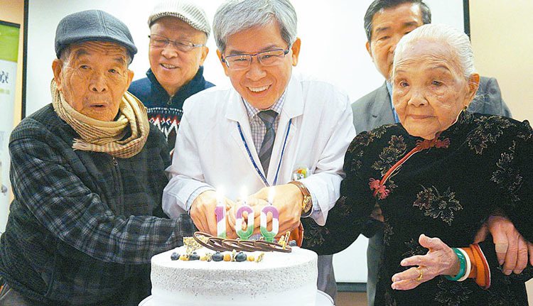 103歲陳王娘(右)、102歲林茂成(左)今天在台中榮總泌尿外科主任歐宴泉(中)祝福聲中切蛋糕慶生。