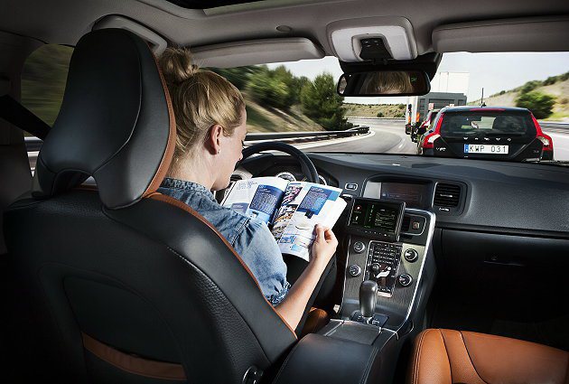 Volvo自動駕駛實驗，駕駛雙手完全離開方向盤而專心看雜誌。 Volvo