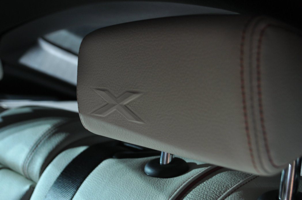 座椅頭枕有著X車款的辨識徽章。 記者許信文／攝影