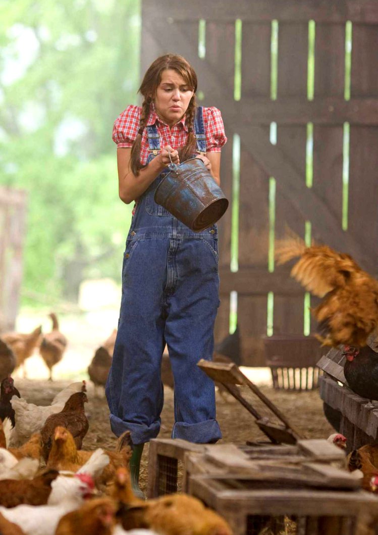 麥莉在「孟漢娜電影版」來到農場餵雞騎馬，過起純樸的鄉村生活。圖／迪士尼