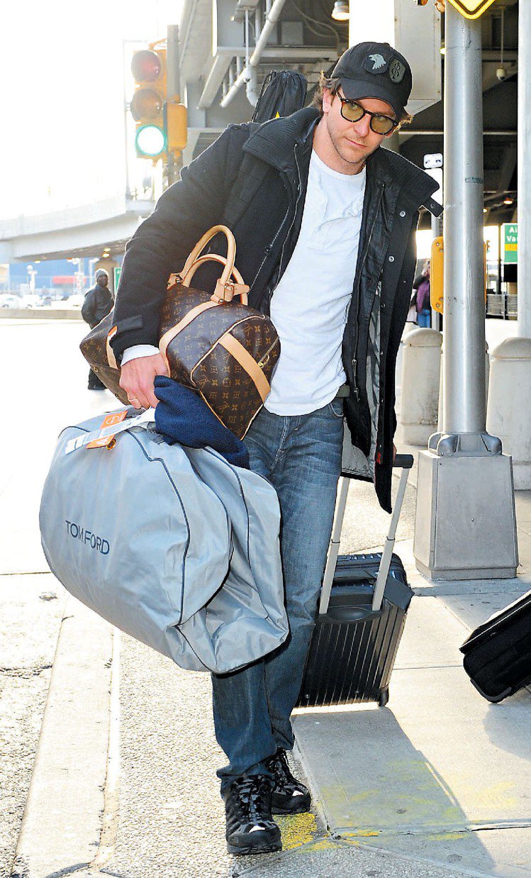 性格男星布萊德利古柏抱著 LV Carryall包款，適合外出旅行使用。圖／LV提供