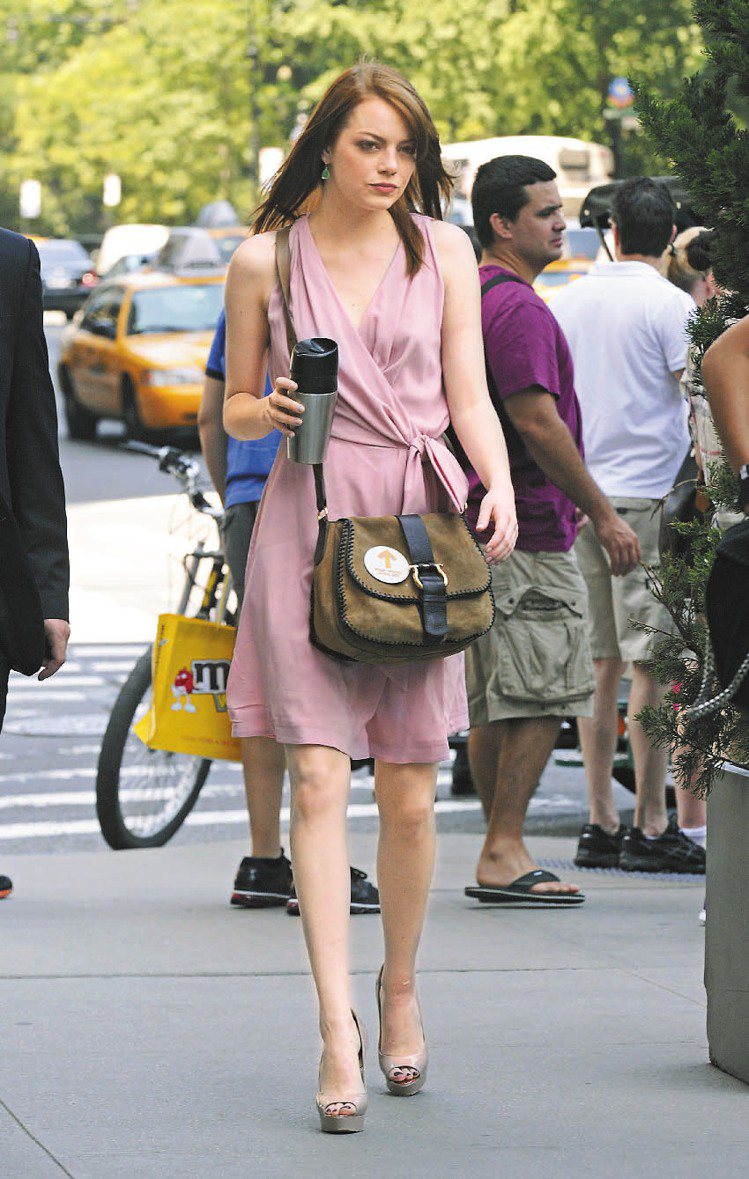 艾瑪史東也會選穿亮色系服裝，如粉紅色小洋裝，多了點嫵媚的性感。圖／達志影像