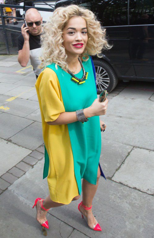 Rita Ora穿上綠、藍、黃拼接的洋裝搭配桃紅色PVC紅底鞋、螢光黃項鍊，全身亮彩的穿法受到許多好評。圖／達志影像