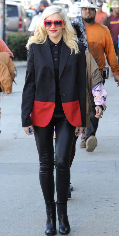 關史蒂芬妮的紅黑拼接西裝外套搭配皮褲、短靴、紅框方型墨鏡，充滿個性時尚味。圖／達志影像