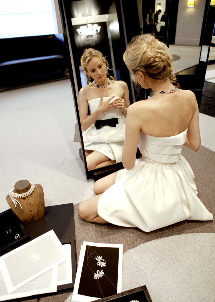 黛安克魯格穿白色小洋裝，陶醉在香奈兒珠寶工坊裡。圖／CHANEL提供