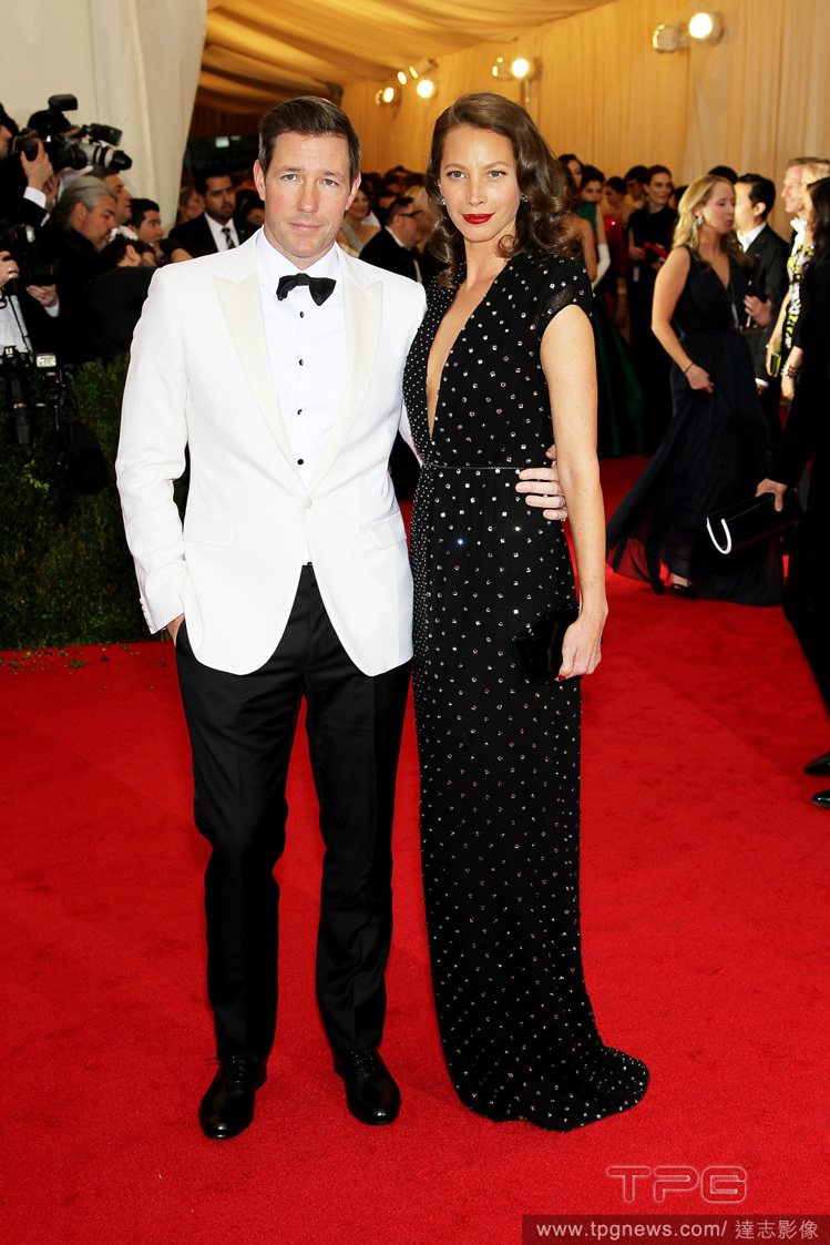 美國超模 Christy Turlington 身穿黑色圓點 V 領禮服，與男星老公艾德華伯恩斯（Edward Burns）的白西裝，散發俏皮優雅的復古氣息。圖／達志影像