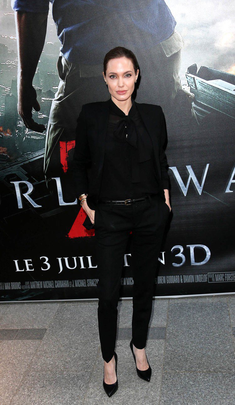 在2013陪小布宣傳《末日之戰》時，裘莉穿 Saint Laurent 黑色褲裝綁起馬尾看起來神采奕奕，摩登時尚。圖／達志影像