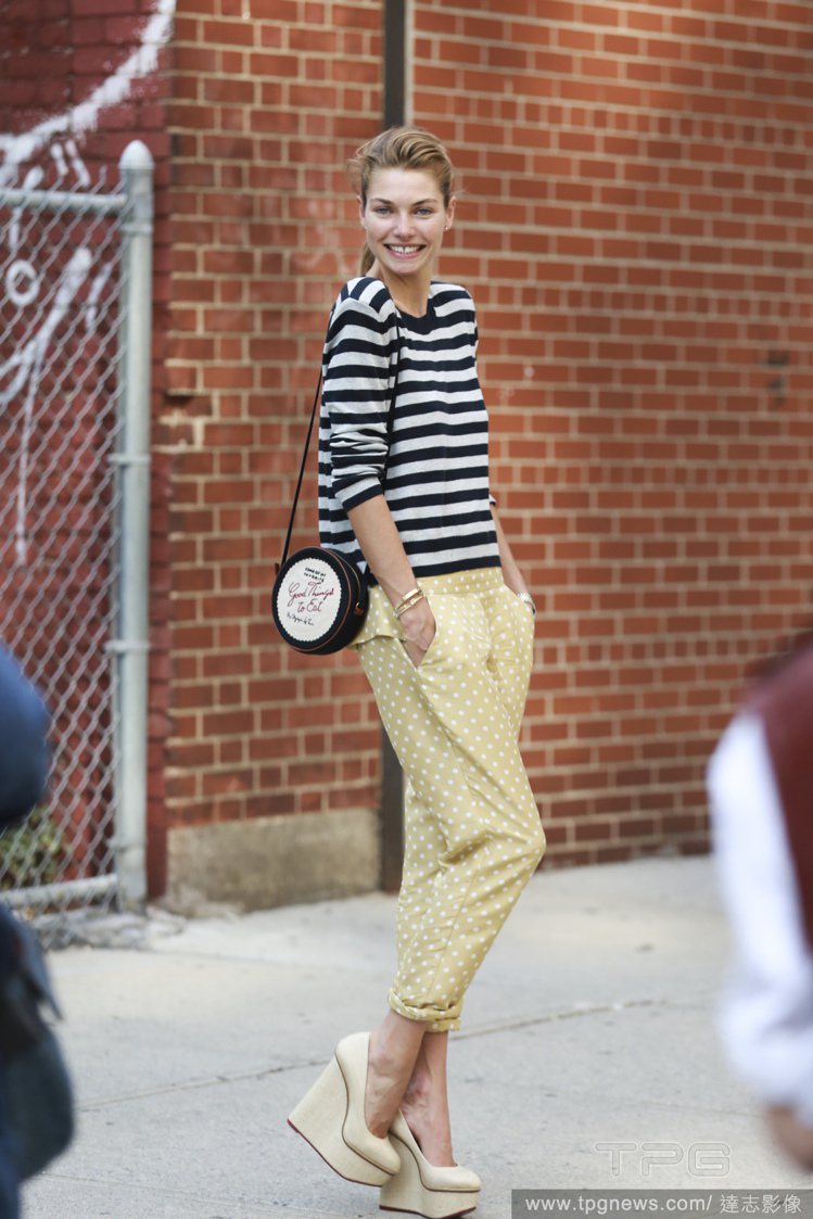 Jessica Hart 身穿黑白條紋衣搭配芥末黃點點褲，搭配楔型鞋與造型包款不但削弱休閒味，還帶來俏皮的街頭氣質。 圖／達志影像