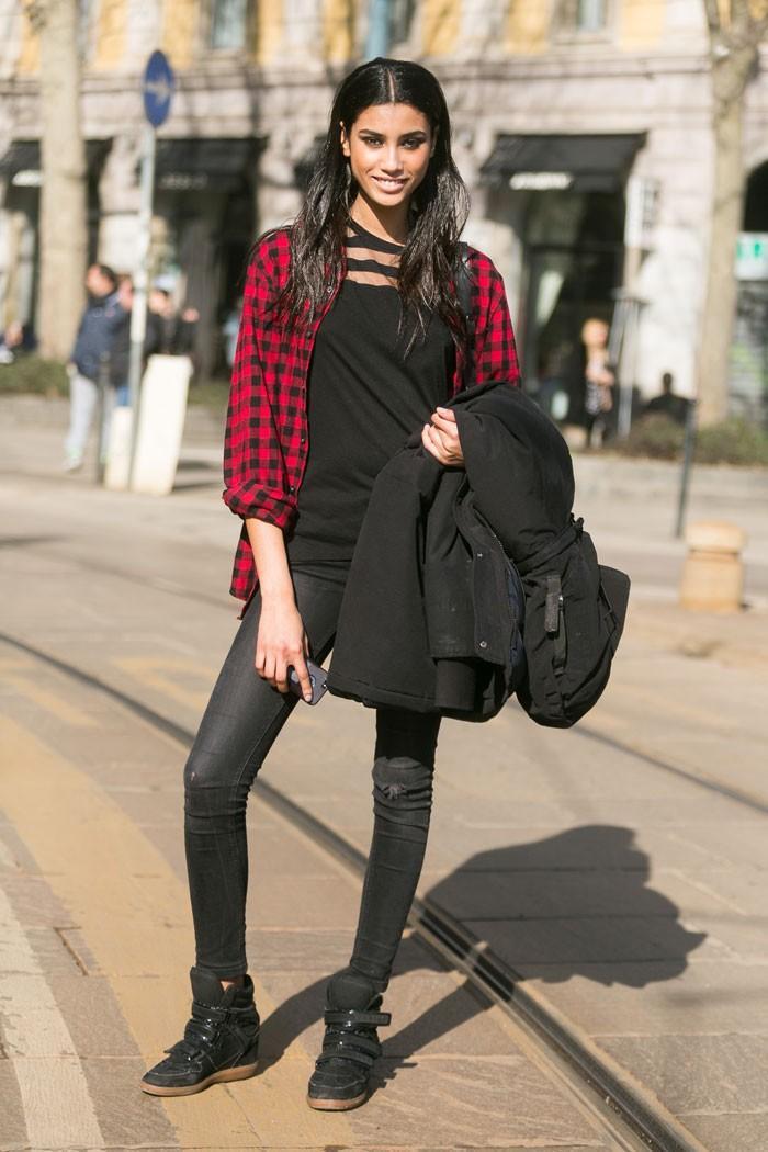 黑色上衣肩部的鏤空細節略顯性感，搭配窄管褲與運動鞋完成一身酷黑打扮，格紋襯衫為整體注入一絲活潑氣息。圖／擷自models.com