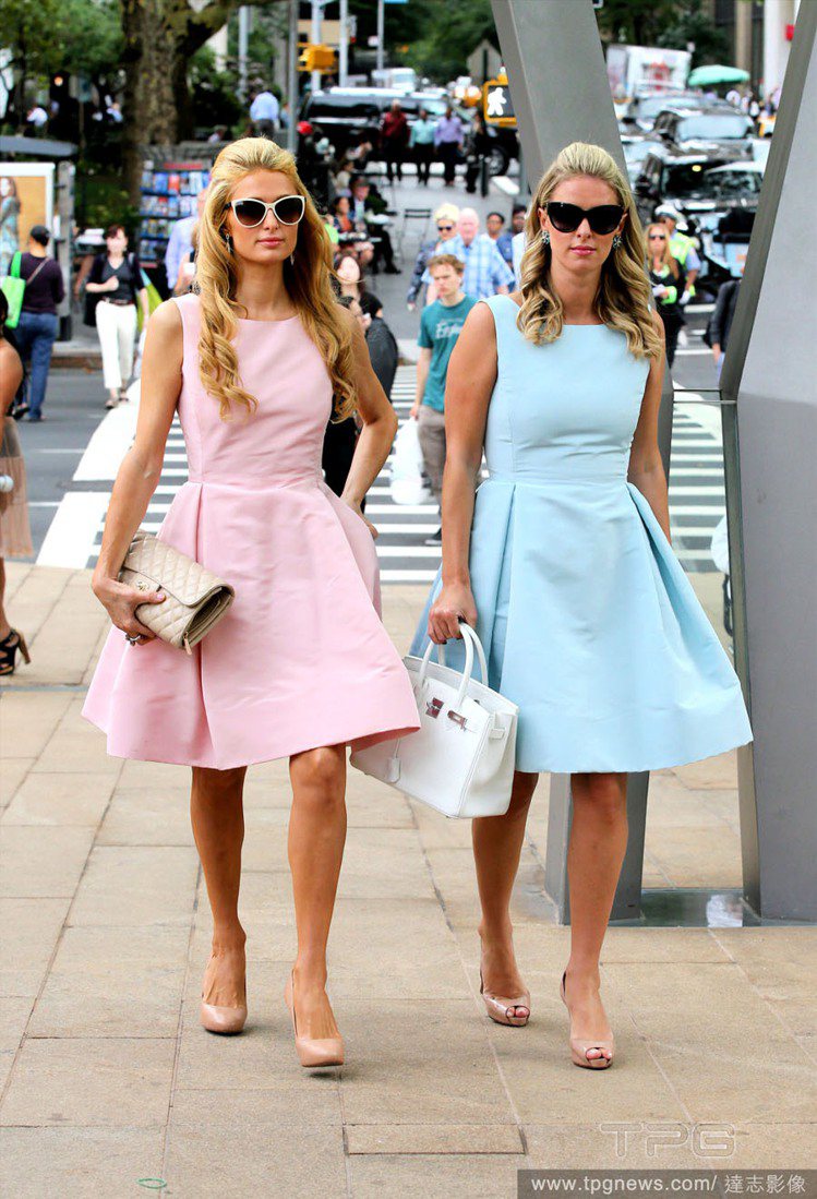 希爾頓姊妹最近熱愛「假雙胞胎 」穿搭術，粉彩洋裝讓她們看來就像兩個真人芭比。圖／達志影像