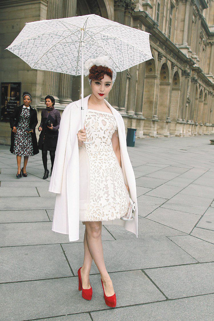 范冰冰造在巴黎時裝周的LV秀場外，穿著LV春夏縷空洋裝，撐起蕾絲洋傘，頗有古典風情。圖／達志影像