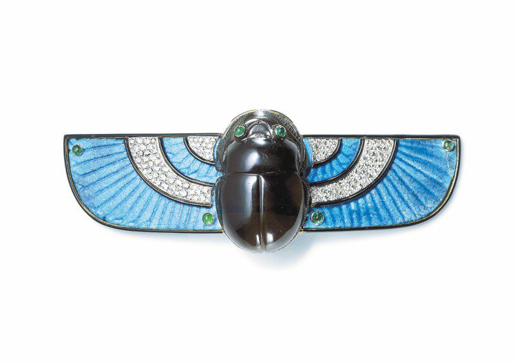 聖甲蟲胸針，受埃及風格影響，聖甲蟲也是珠寶造型靈感，1924年作品，鑲嵌埃及錫釉藍陶、鑽石、祖母綠和墨晶。圖／Cartier提供