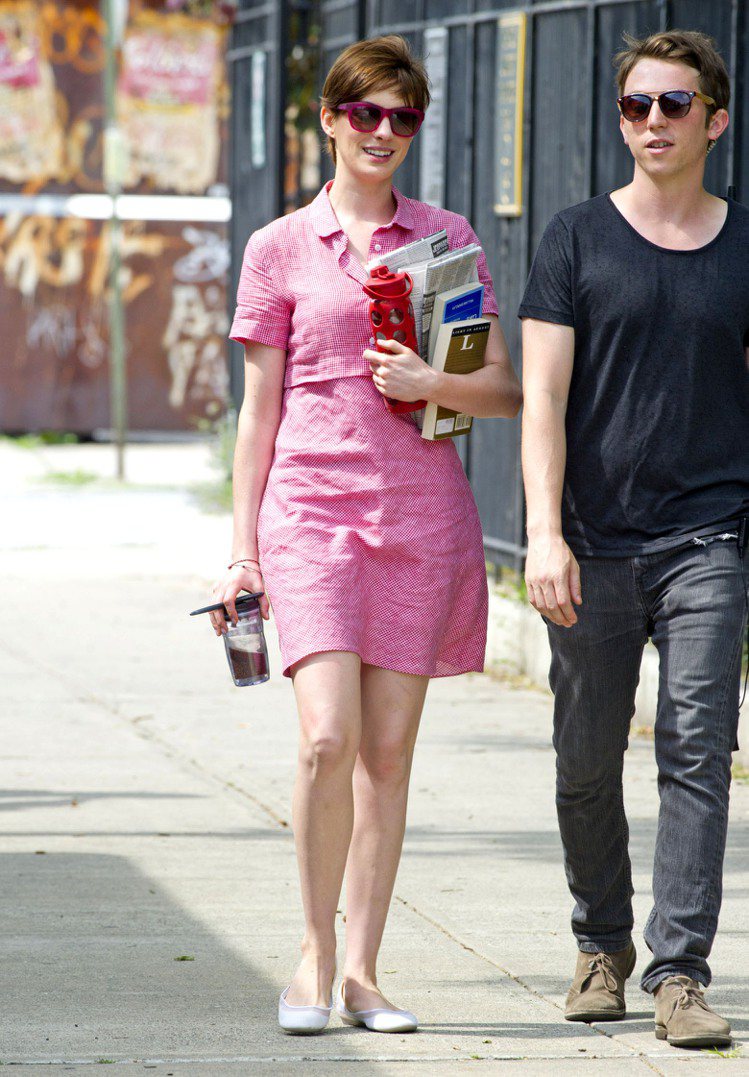 安海瑟薇穿著粉桃色洋裝，配雙平底鞋輕鬆上街。圖／達志影像