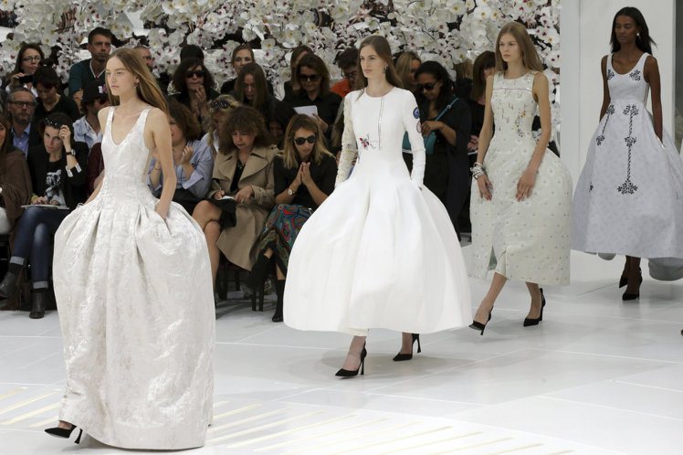Dior 高級訂製服在白色蘭花海下如夢似幻。圖／擷取自nytimes.com