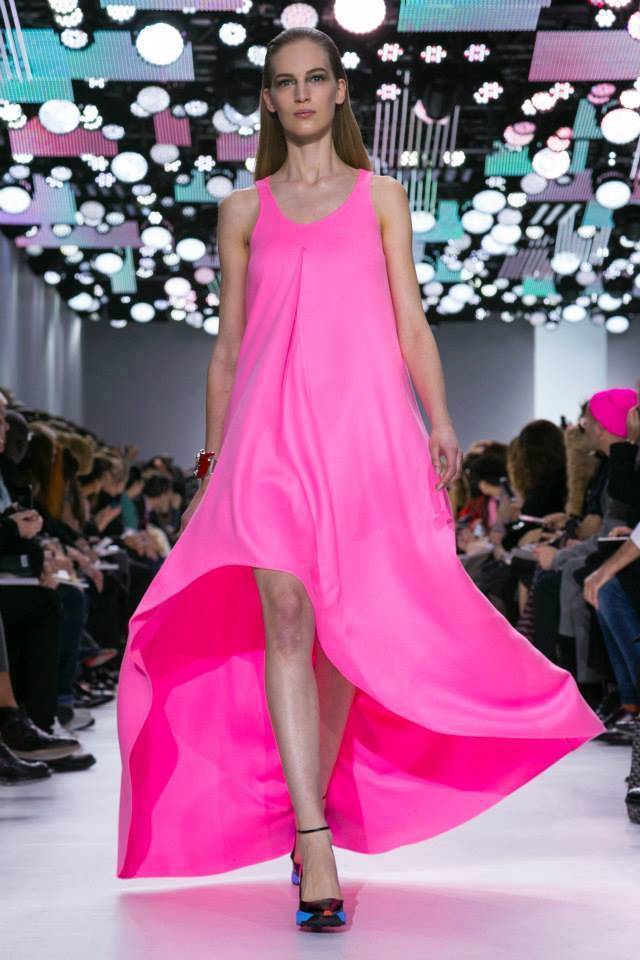 Dior 的粉紅洋裝帶點螢光質感，極簡剪裁前衛亮眼，前短後長的設計走起路來也特別飄逸瀟灑。圖／擷自newfashioncorner