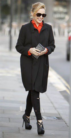 凱莉米洛領口露出的橘色襯衫領點亮黑色大衣。圖／達志影像提供