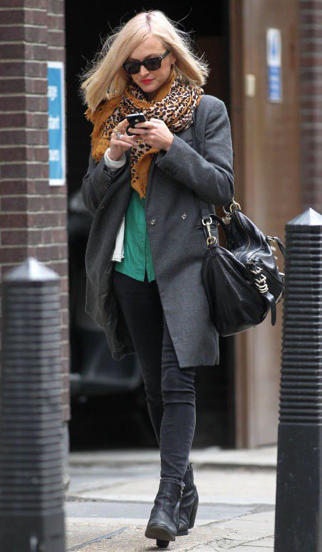 菲妮柯頓穿上灰色毛大衣和窄管牛仔褲，搭配與綠色襯衫超合襯的豹紋圍巾。圖／達志影像